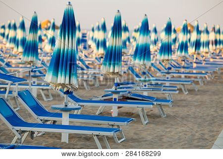 Rimini Beach With Blue Sun Umbrellas. Rimini, Italy. Rimini Seashore. Tropical Resort In Italy.