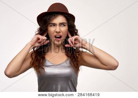 Dissatisfied Woman Pluggs Ears, Exclaims Loudly, Opens Mouth,  Ignores Annoying Sound, Stands Over W