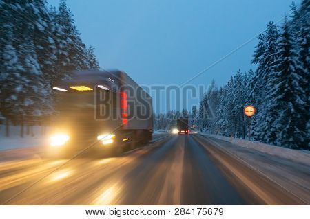 Cars Drive  With Headlights On The Winter Road In A Snow Storm In The  Twilight  When Snow Is Flying