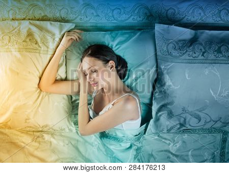 Beautiful young woman sleeping in luxury bed. Bed is made with linen embroidered percale.