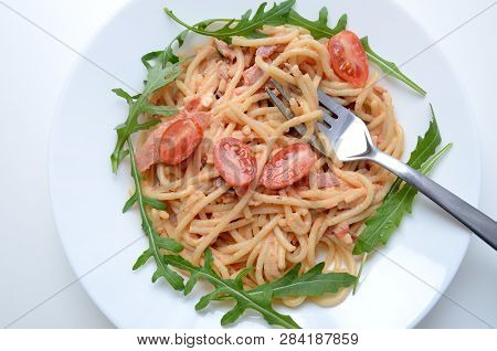Spaghetti With Schurwald Ham, Sauce And Fresh Argula, Tomatos. Pasta On White Plate With Silver Fork