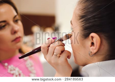 Make Up Artist Doing Professional Make Up Of Young Woman