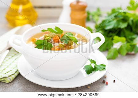 Summer Light Vegetarian Vegetable Soup With Carrot, Potato, Cabbage And Grean Peas On White Backgrou