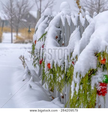 Fence With Festive Garland On A Snowy Day In Utah