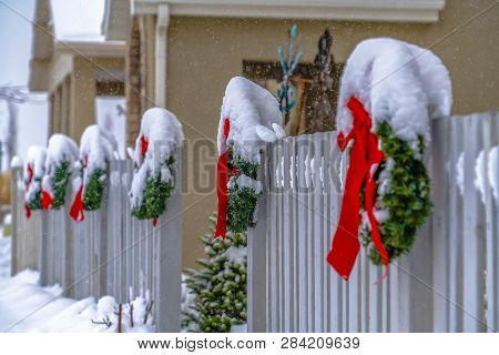 Festive Picket Fence With Snowy Wreaths In Utah