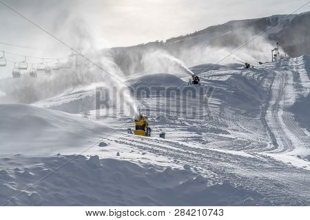Snow Guns And Ski Lifts On Snowy Slope