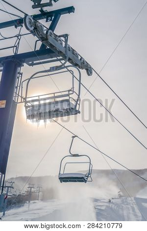 Snowy Chair Lifts Against Bright Sun In Park City