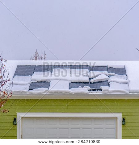 Snowy Garage Roof With Solar Panels In Winter
