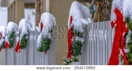 Snowy Wreaths Lining A Picket Fence In Winter
