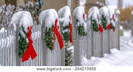 White Fence Lined With Christmas Wreaths In Utah