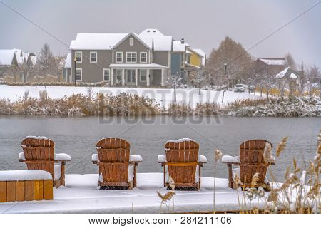 Wooden Chairs On Snowy Lake Deck In Daybreak Utah