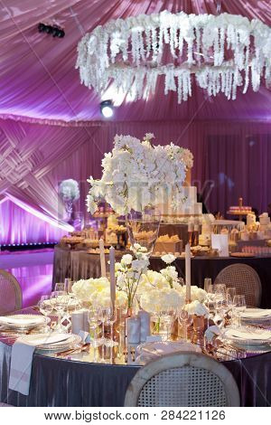 Moody backlit ambience of a wedding reception, luxury elegant table setting