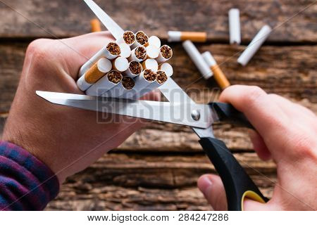 Smoker Cuts A Cigarette With Scissors. Stop Smoking Cigarettes Concept