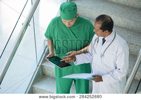 Chief Doctor Consulting Surgeon About X-ray Of Patient On Tablet Computer