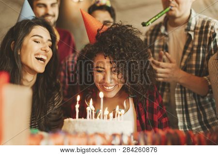 Excited Girl Ready To Blow Out Candles On Cake On Birthday Party With Happy Friends. Happy Birthday 