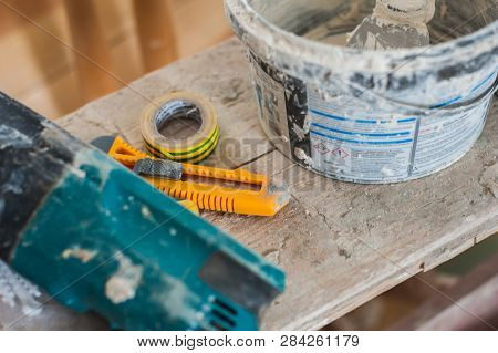 Working Gloves. Do Makeovers. Putty Knife Lying On The Bucket. Tools For Construction And Repair. Se