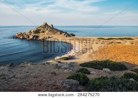 Small Alagadi Beach Panorama With Peninsula And Dry Pasture With Grazing Sheep
