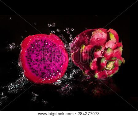 Splashing Fresh Pitaya Falling In Water Tropical Dragon Fruit Or Pitaya Isolated On Black Background