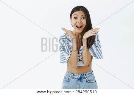Portrait Of Charmed And Enterteined Emotive Dark-haired Attractive Female In Cropped Top And Jeans S
