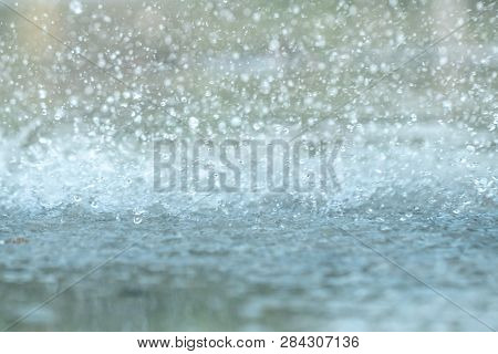 Rain Drops Falling In A Big Puddle On Urban Asphalt In The Town. Raindrops Close-up, Bad Weather In