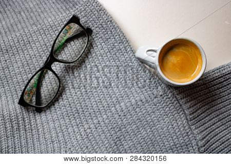 The Cup Of Coffee With The Glasses And Gray Sweater