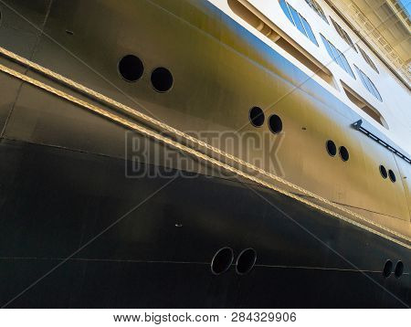Rope Mooring Lines, Portholes And Windows Near Bow Of Berthed Cruise Ship.