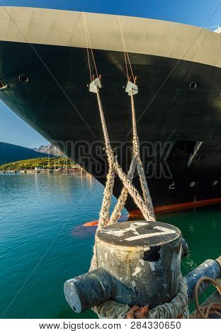 Mooring Lines And Rat Guards Tied At Bow Of Cruise Ship And Dock Bollard In Alaskan Deepwater Termin