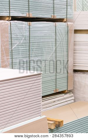 Gypsum Plasterboard In The Pack. The Stack Of Gypsum Board Preparing For Construction. Pallet With P