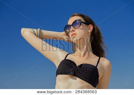 Beautiful Young Woman In Swimsuit Under Sun Rays Tanning, Toned Image