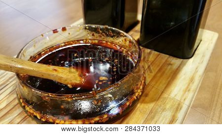 Spicy Hot Dried Chilli In Oil, Complete With Seeds, In A Small Glass Container Sits On A Table In A 