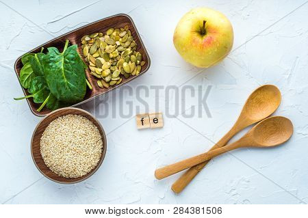 Spinach, Pumpkin Seeds, Sesame, Apple And Two Wood Spoon On A White Background. Microelement Fe. Clo