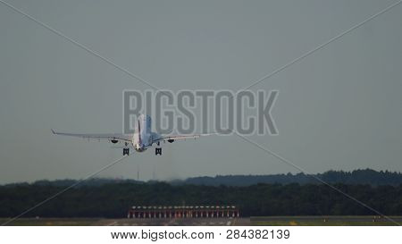 Rear View Of Twin Engine Widebody Commercial Airplane Takes Off