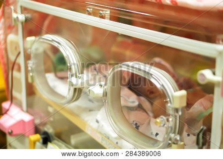 Closeup Sick Newborn Baby Sleeping In A Baby Incubator In A Hospital.