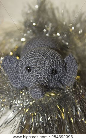 Little Grey Elephant Crochet Wrapped In Yellow Tinsel On White Background