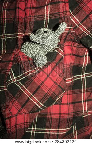Little Grey Elephant Crocheted Sitting In A Pocket Shirt With Red, Black And White Cage
