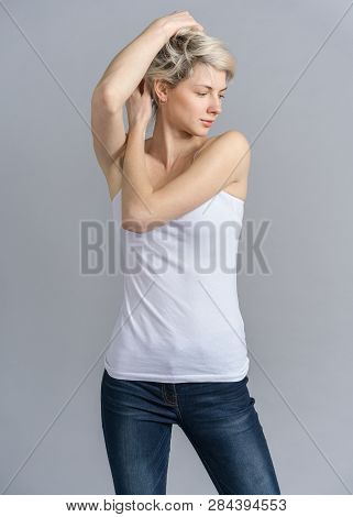 Girl Studio Snap, Model Turning Head Away. Woman With Short Blond Haircut In Casual Outfit, Hands To