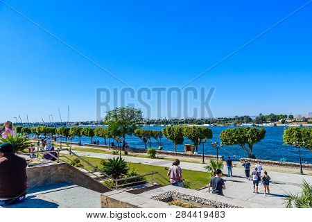 Luxor, Egypt - December 11, 2018: People Walking On Embankment Of Nile River In Luxor, Egypt