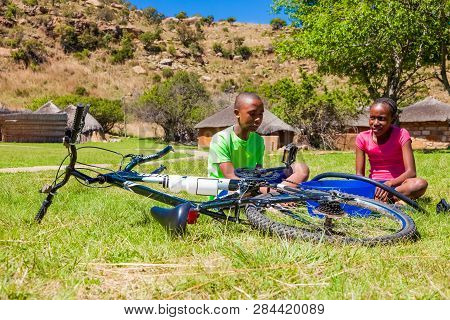 African Children Fixing A Puncture On A Bike