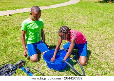 African Children Fixing A Puncture On A Bike
