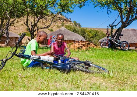 African Children Fixing A Puncture On A Bike