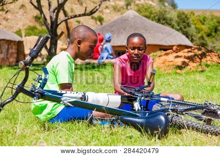 African Children Fixing A Puncture On A Bike