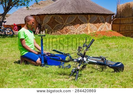 African Children Fixing A Puncture On A Bike
