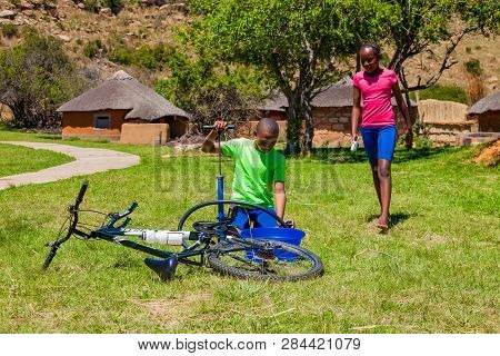 African Children Fixing A Puncture On A Bike