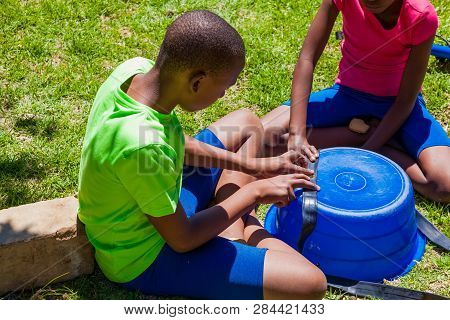 African Children Fixing A Puncture On A Bike