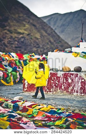 Tagong, China On 12th May 2015 - View On Girl With Yellow Umbrella Going Arround Tibetan Stupa