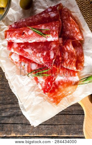 Italian Salami With Olives And Spices On Wooden Background