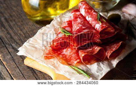 Italian Salami With Olives And Spices On Wooden Background