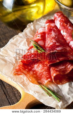 Italian Salami With Olives And Spices On Wooden Background