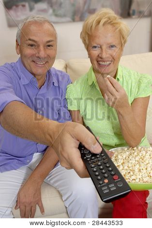 casal sênior feliz assistindo televisão juntos.Casal sênior mudar canais de televisão.