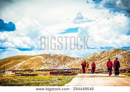 Tagong, China On 12th May 2015 - View On Group Of Tibetan Monks Walking In Mountain Landscape